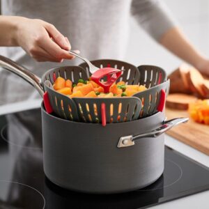 Folding steamer basket in grey/red by Joseph Joseph with silicone feet and fork hook