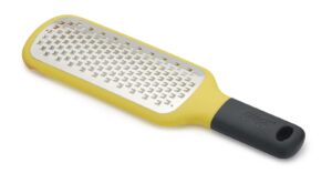 Coarse paddle grater with bowl grip in yellow by Joseph Joseph, with stainless-steel blade